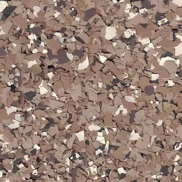 A close-up of brown, white, and black speckled flakes creating a textured surface, resembling stone or decorative flooring. No landmarks visible.